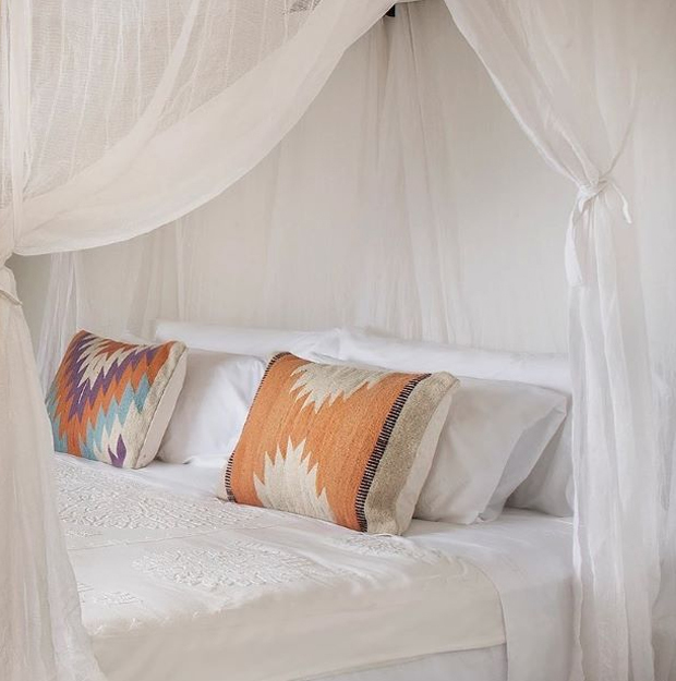 Soft white mosquito net over a calm bedroom