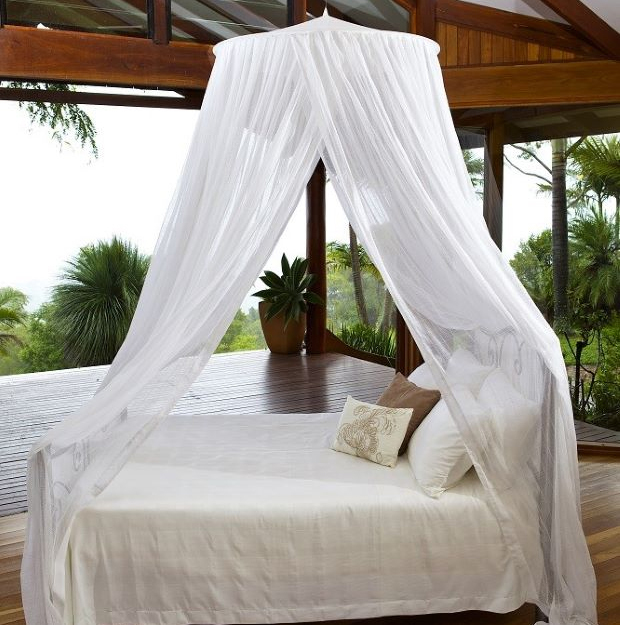Round mosquito net hanging from a single ceiling point